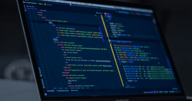 Close-up of a developer's laptop screen showing colorful source code in a modern AI-powered editor